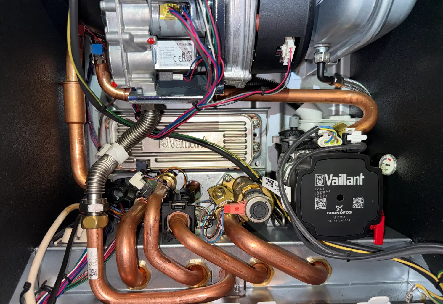 Inside a domestic boiler showing pipework, wiring and the circulation pump